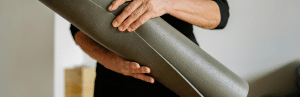 Picture showing the hands of a man carrying a yoga mat