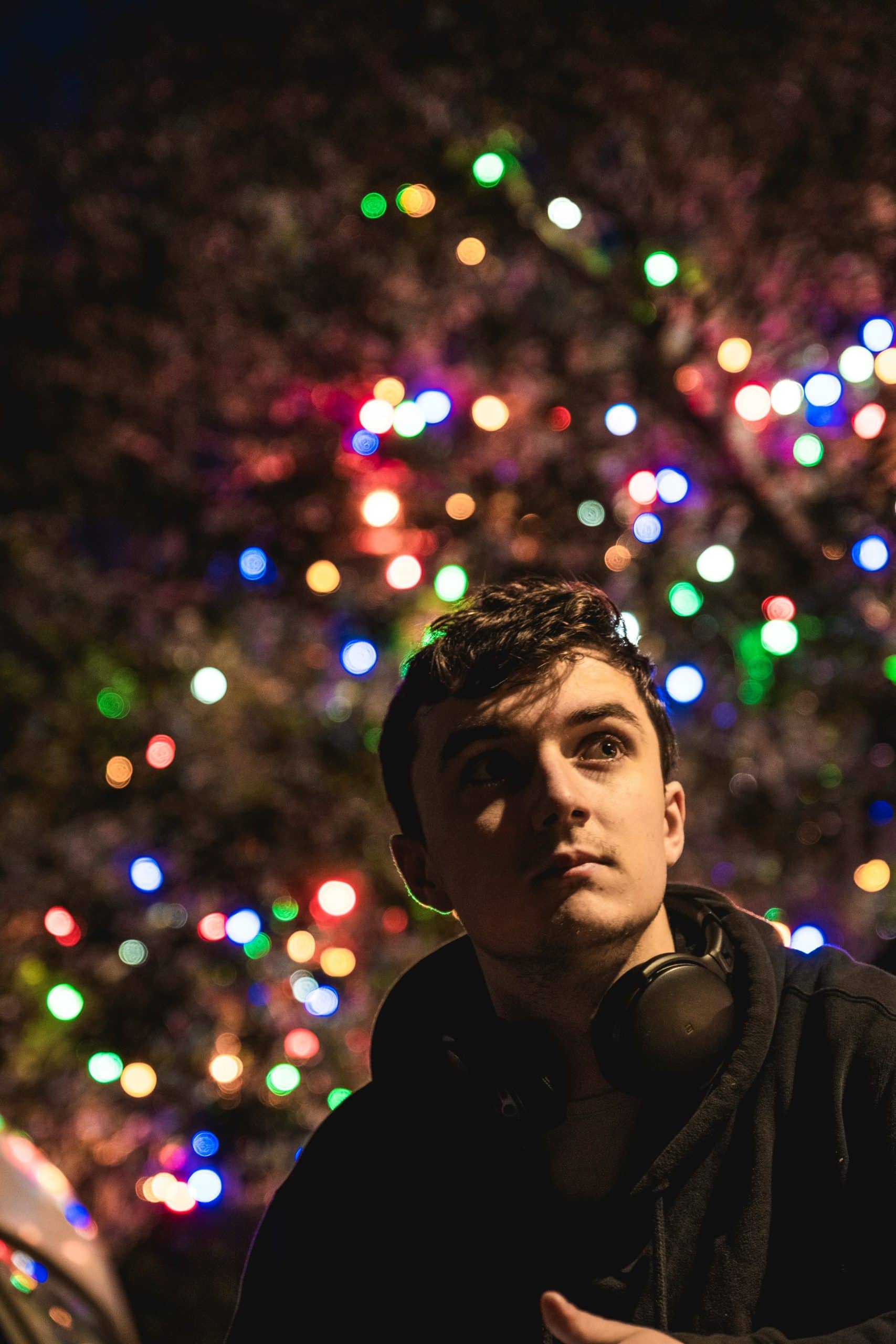 Young man standing in front of Christmas lights 