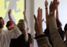 People in a conference with their hands raised