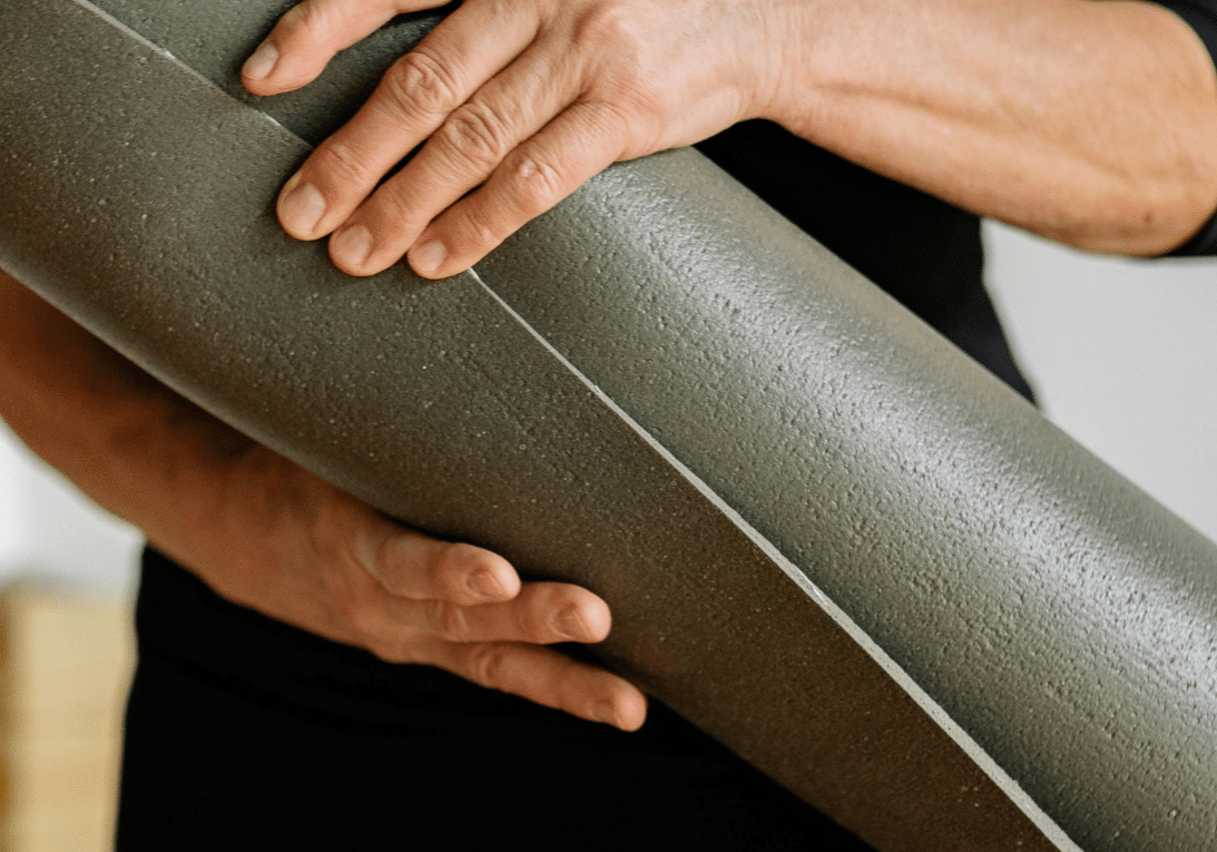 Picture showing the hands of a man carrying a yoga mat